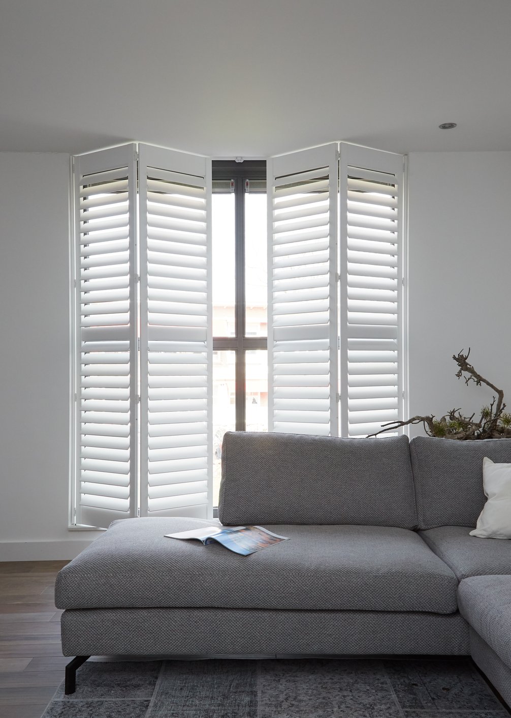 Witte shutters met grijze bank