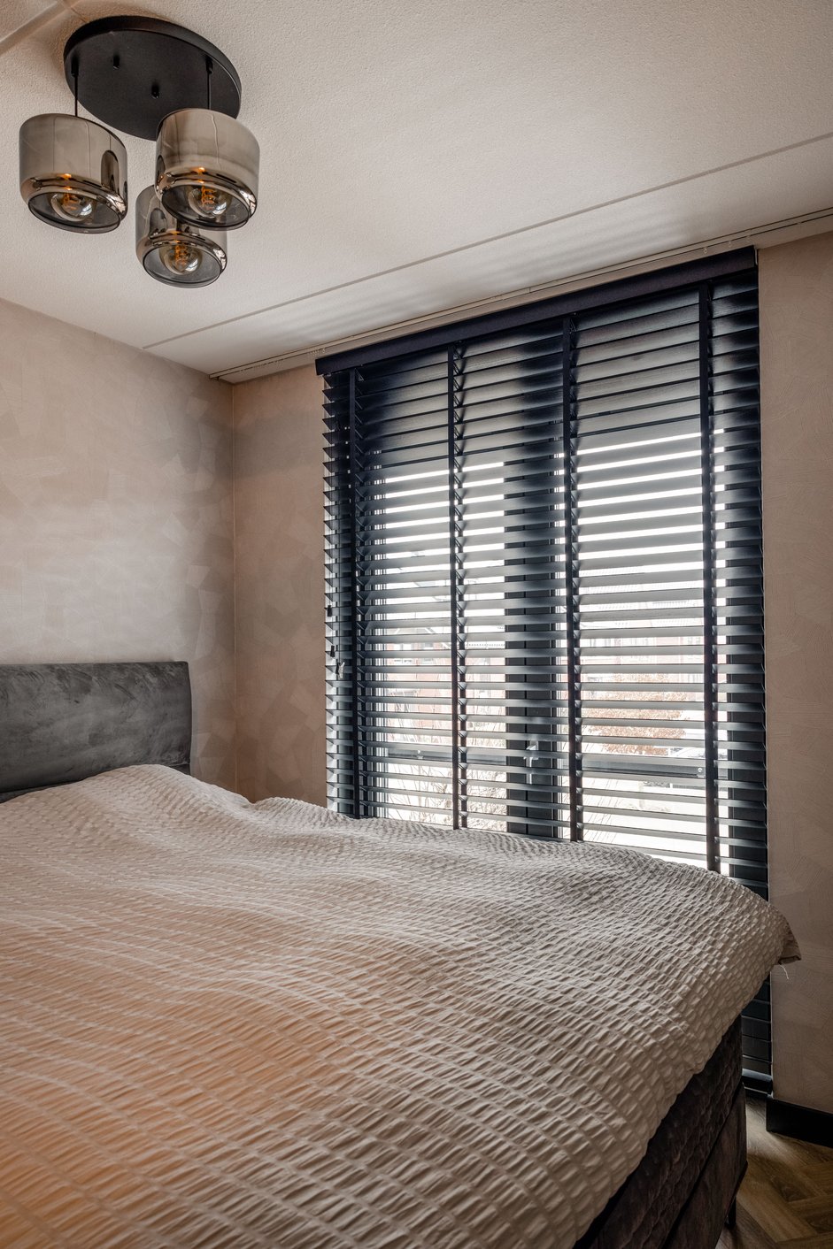 Zwarte houten jaloezieën in de slaapkamer
