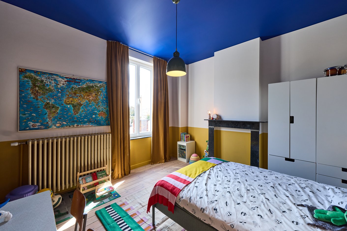 Kinderkamer met gordijnen en blauw plafond