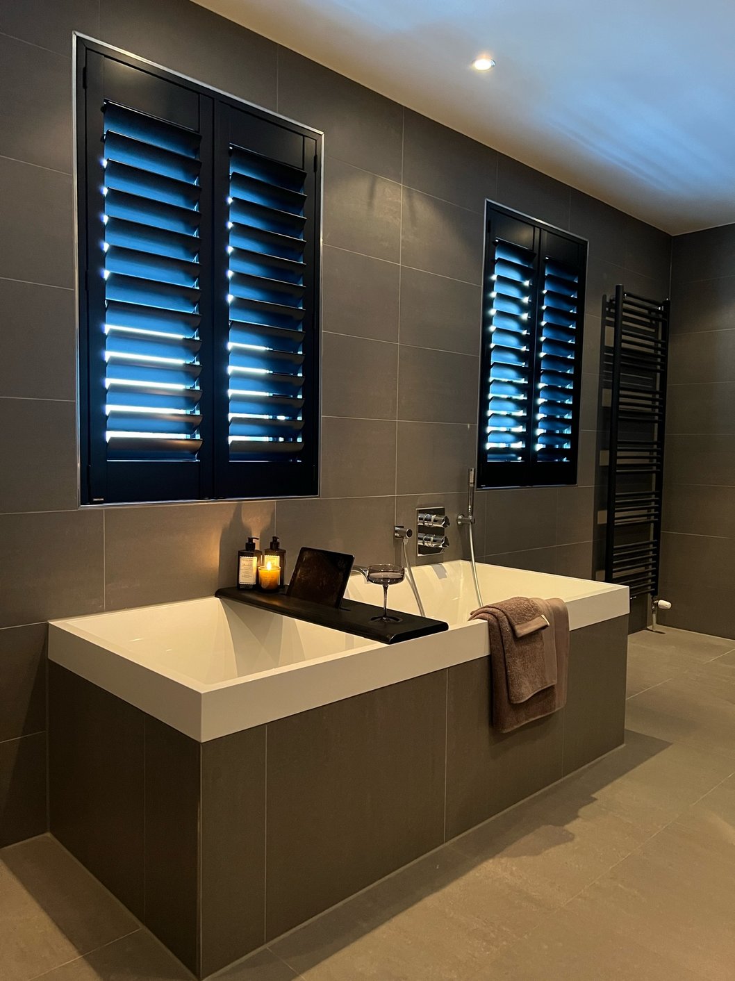 Zwarte shutters in een luxe badkamer