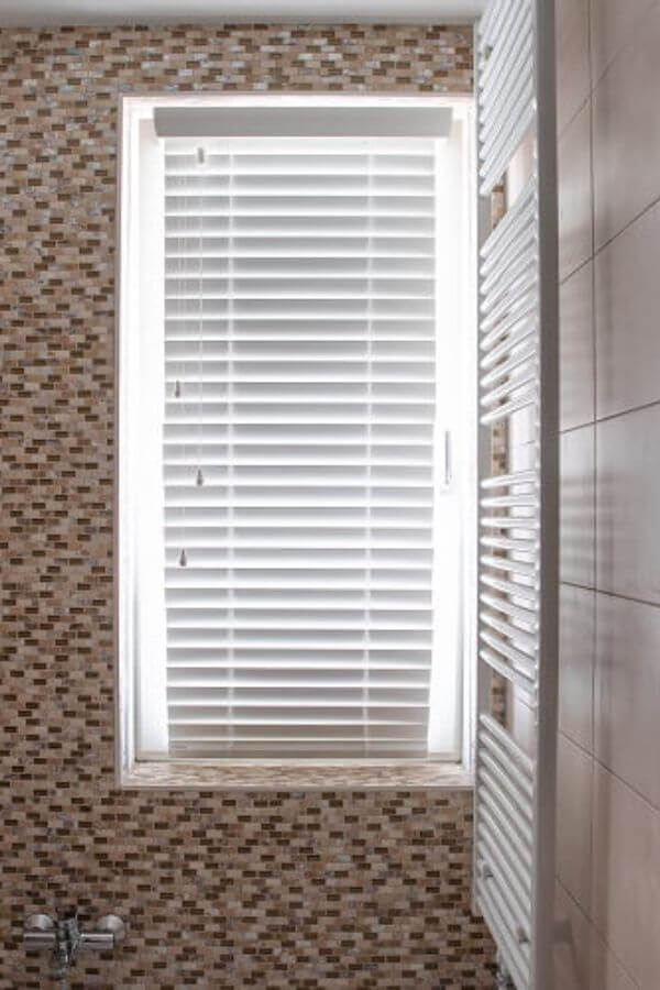 Witte jaloezieën in badkamer