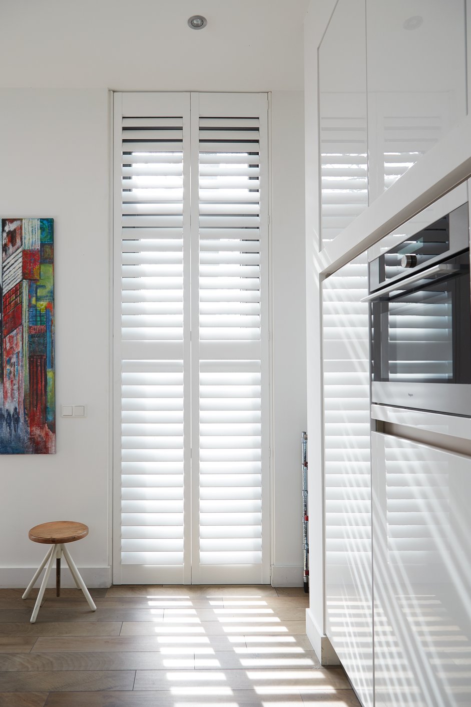 Witte shutters in industriële keuken