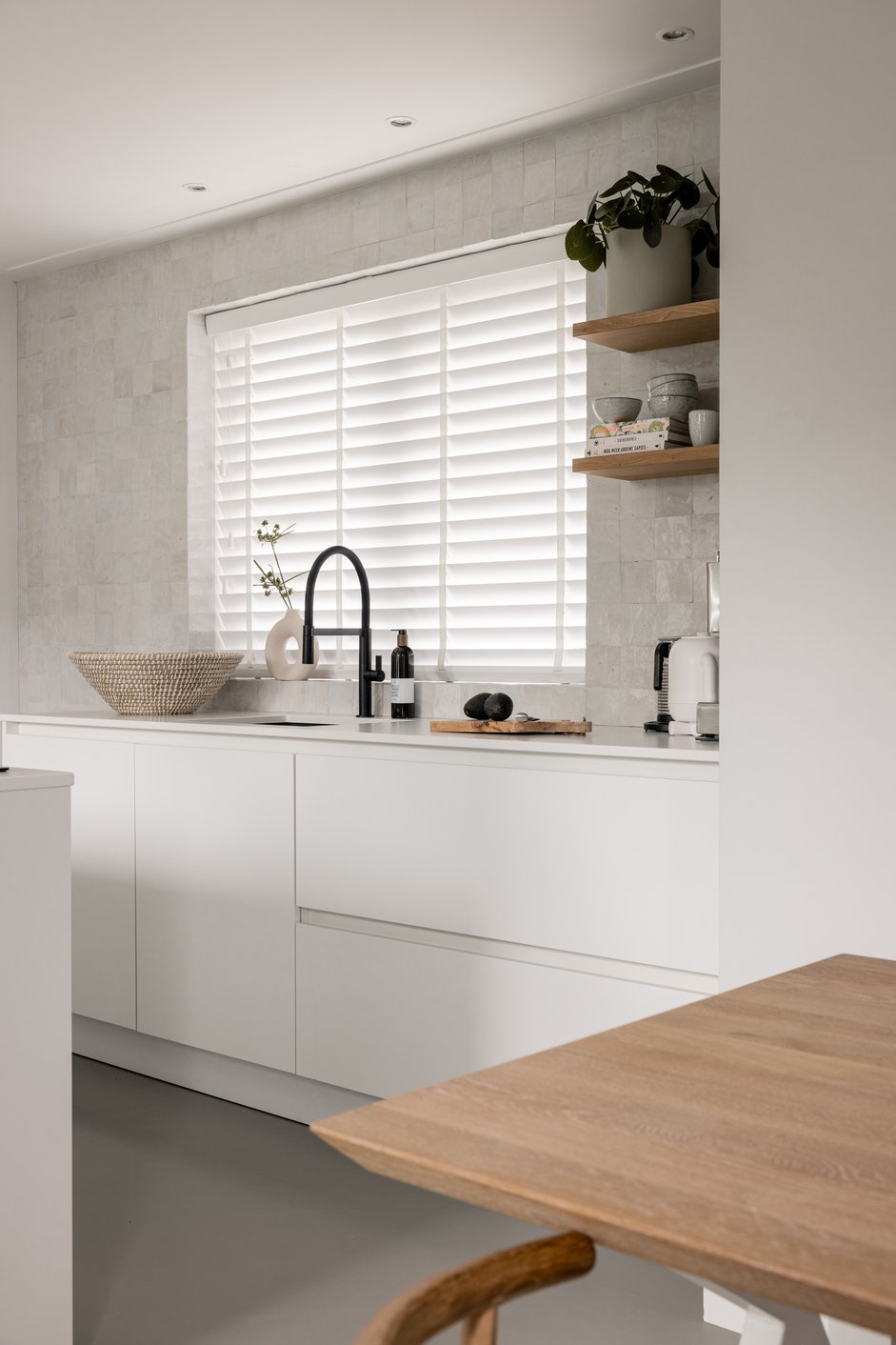 Witte jaloezieën in een Scandinavische keuken