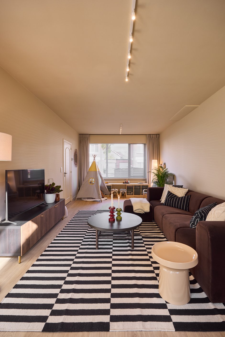 Woonkamer met houten jaloezieën en vitrage gordijnen