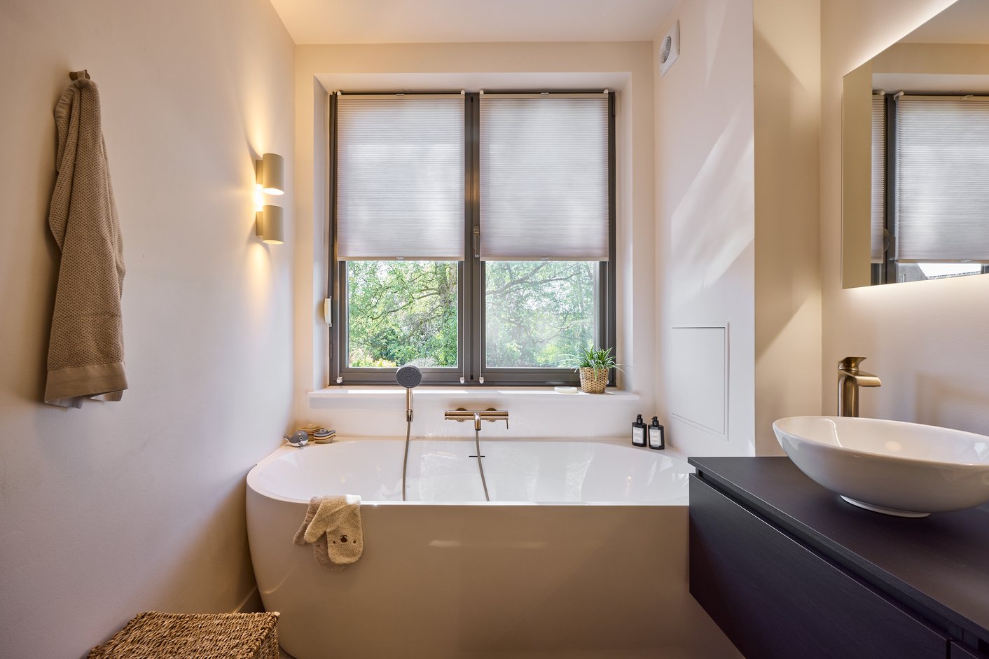 Badkamer met bad en plisségordijnen