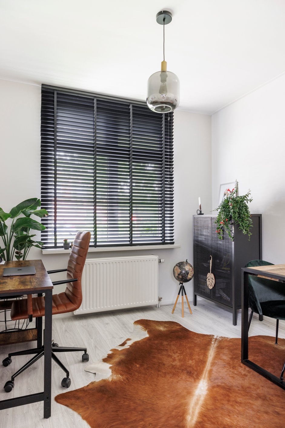 Zwarte houten jaloezieën in werkkamer