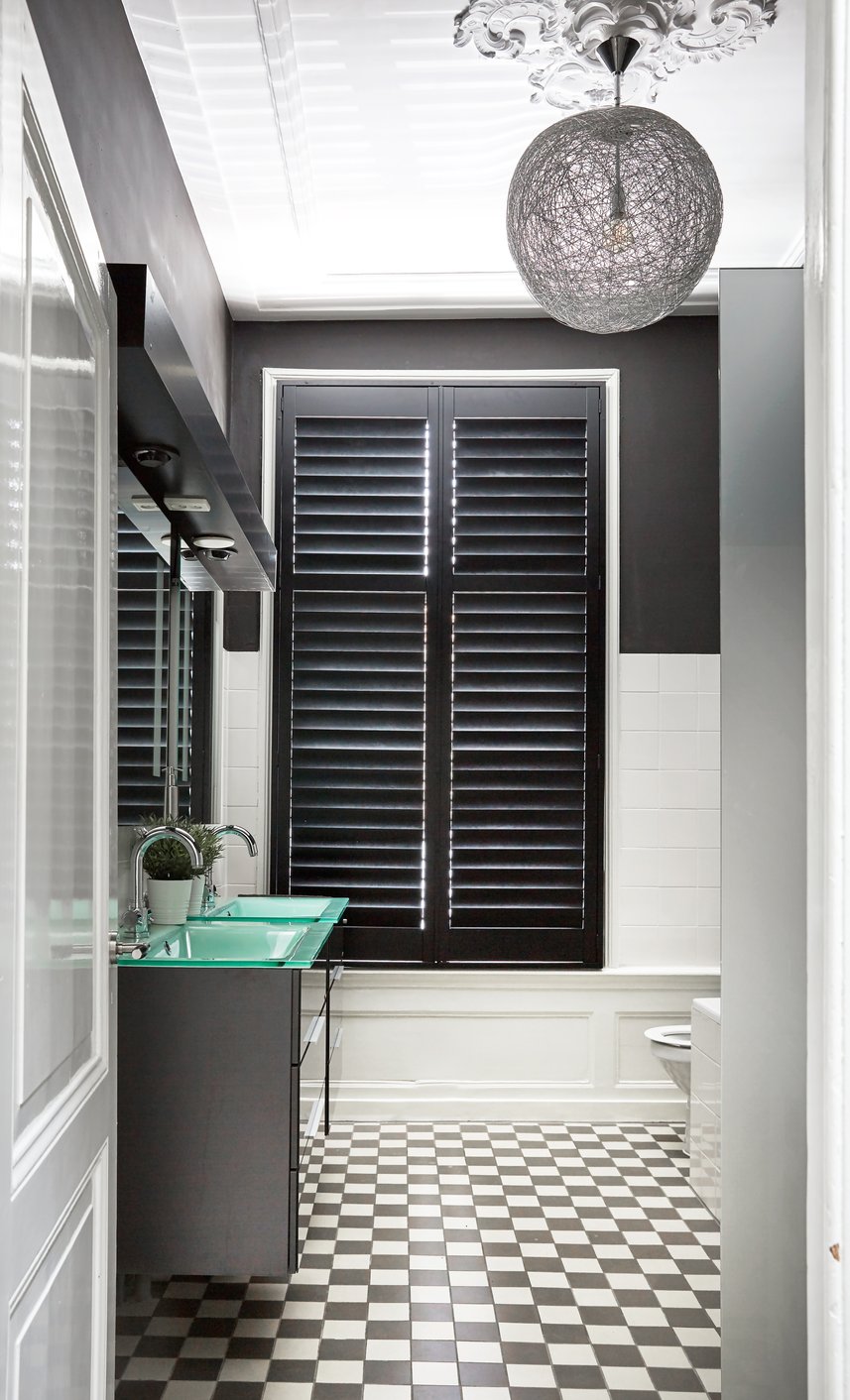 Zwarte shutters in urban jungle badkamer