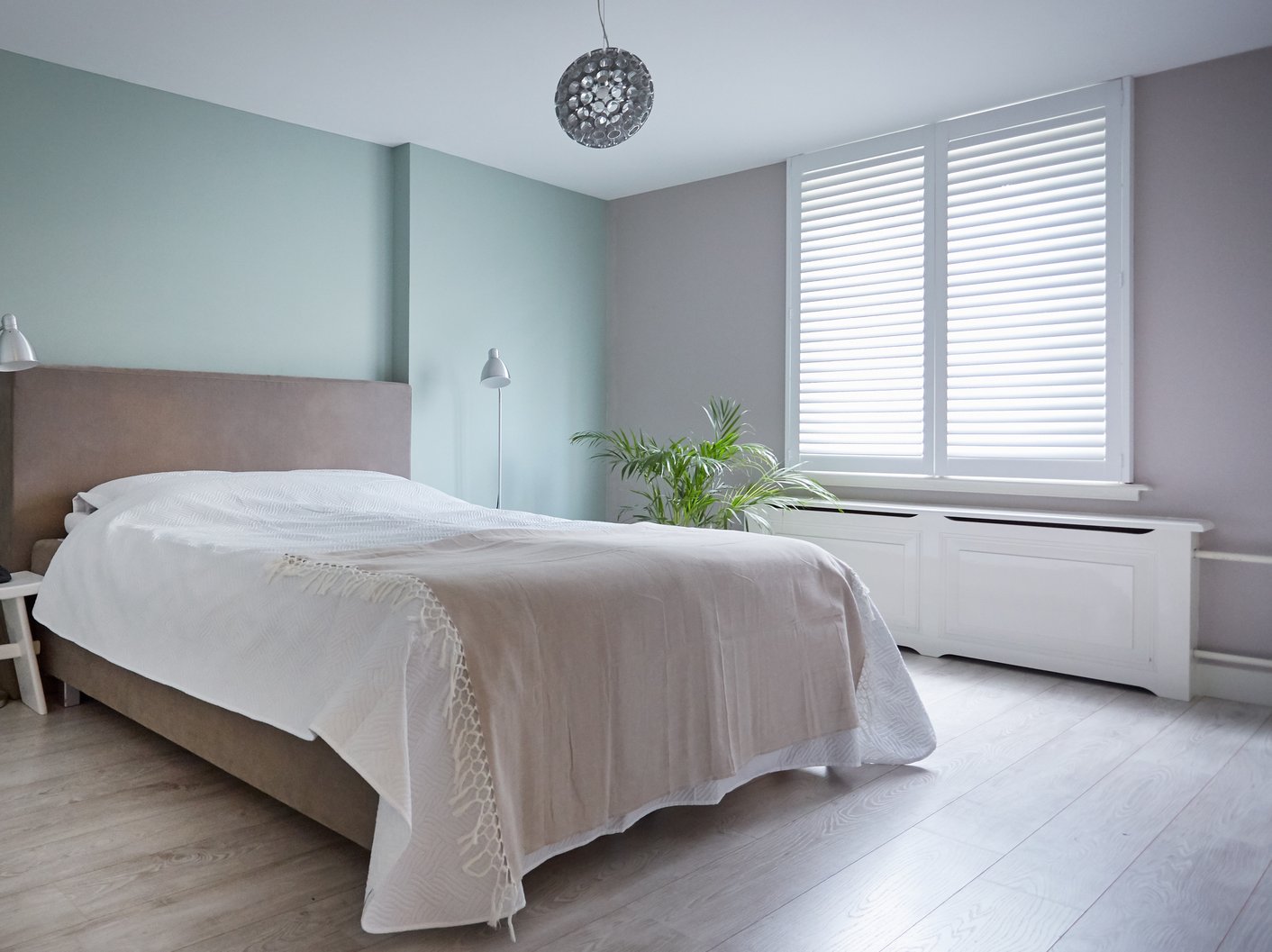 Witte jaloezieën in landelijke slaapkamer
