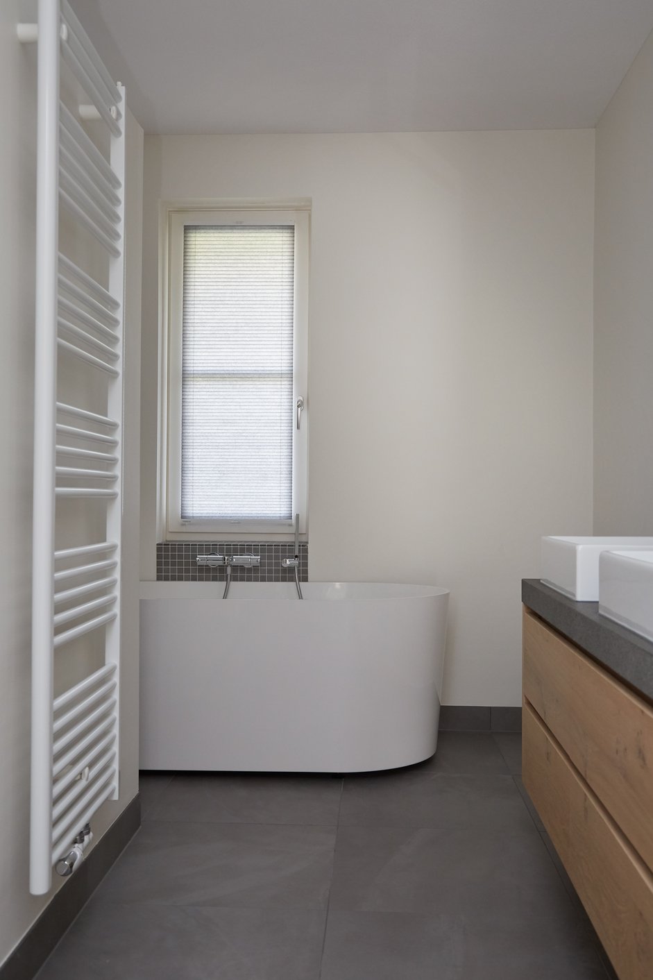 Grijze plisségordijnen in een moderne badkamer