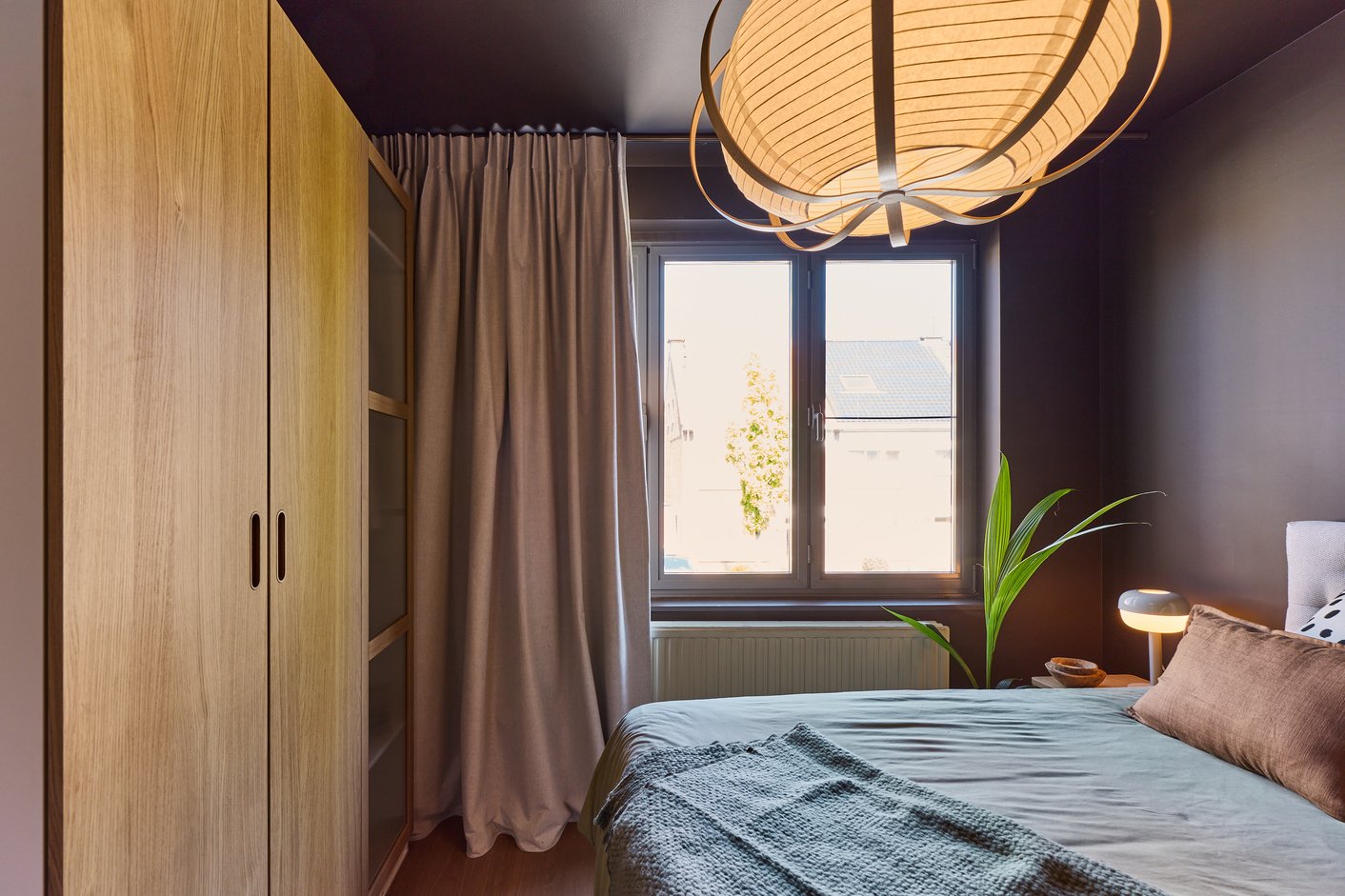 Slaapkamer met gordijn en ronde lamp