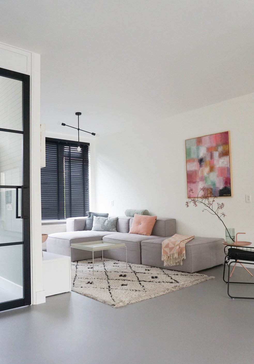 Moderne woonkamer met een grijze gietvloer en bank