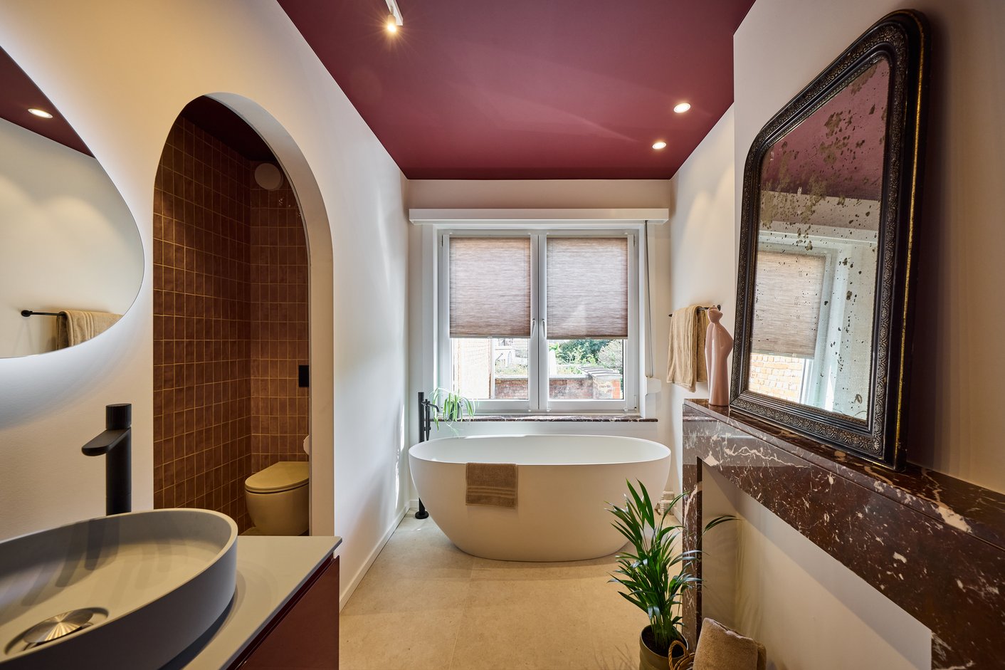 Badkamer met plisségordijnen en rood plafond