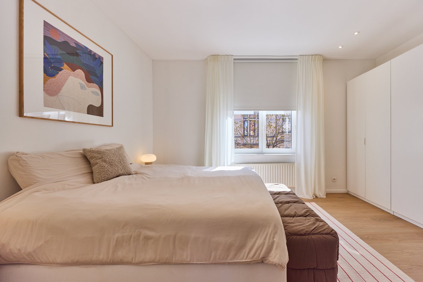 Slaapkamer met rolgordijn en voile gordijnen