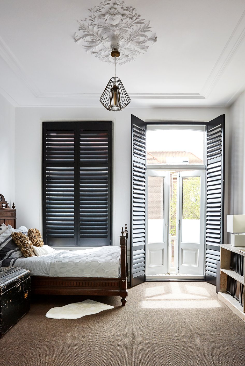Zwarte shutters in landelijke slaapkamer
